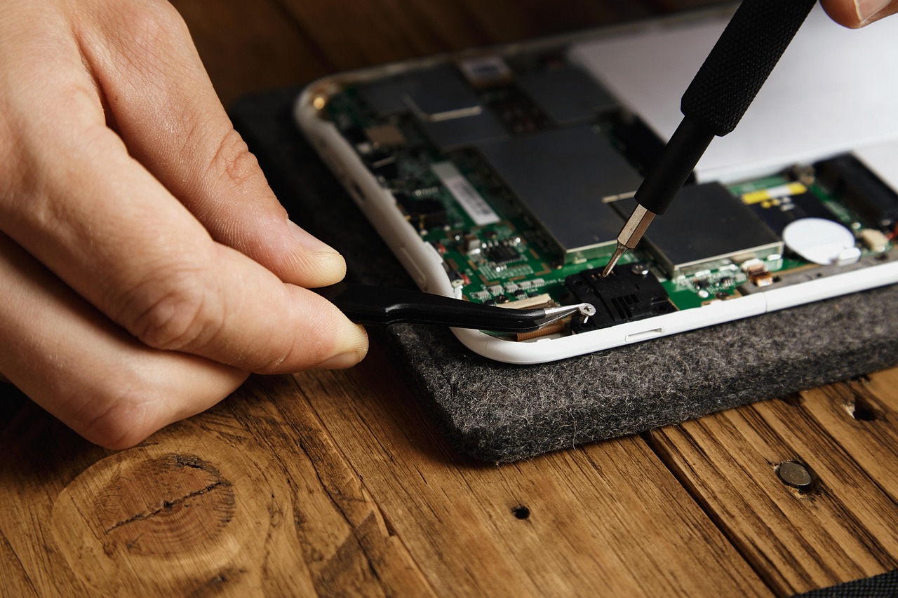 Technician repairing internal components of a smartphone.